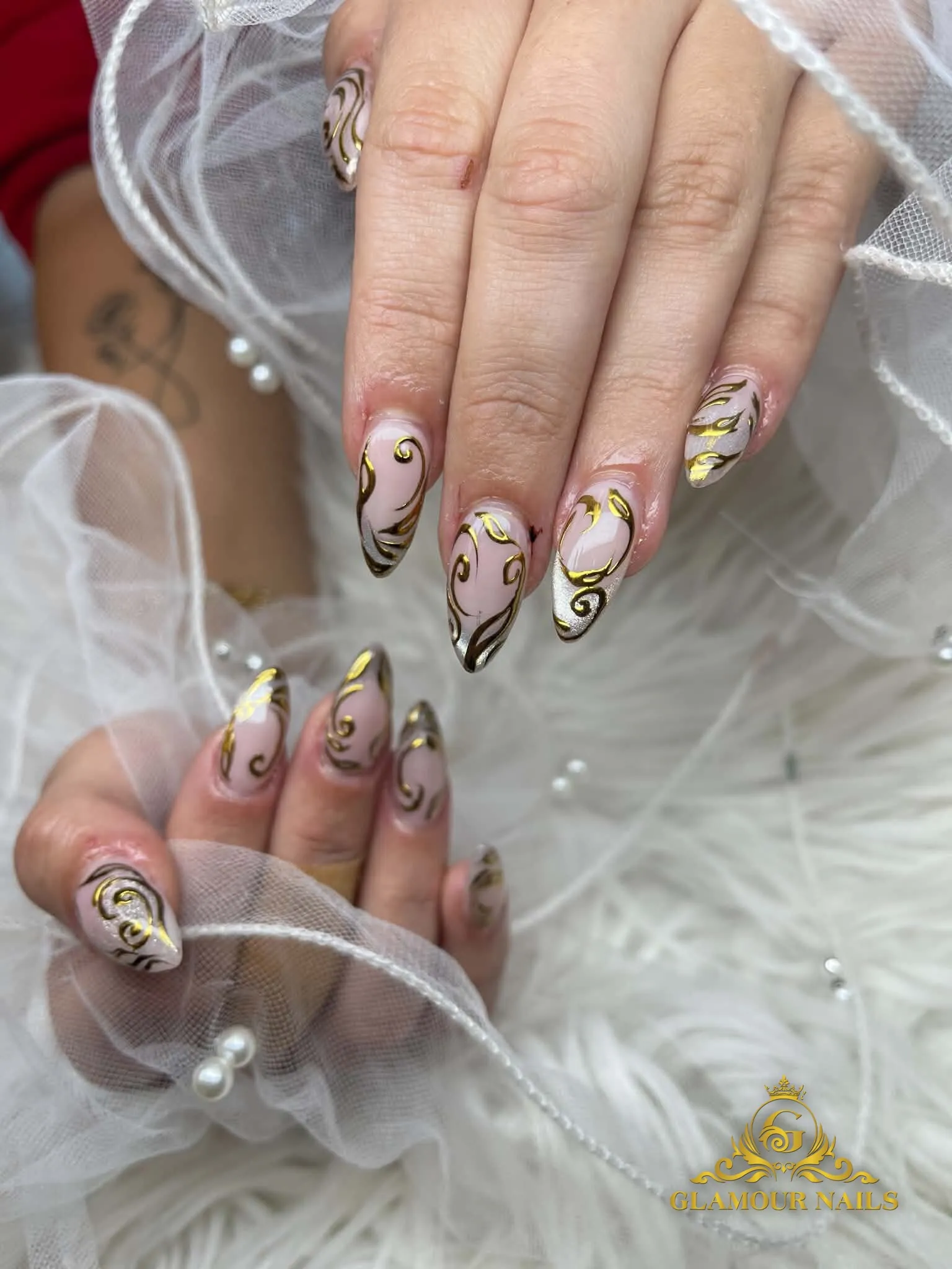 Gold chrome swirls on nude almond nails