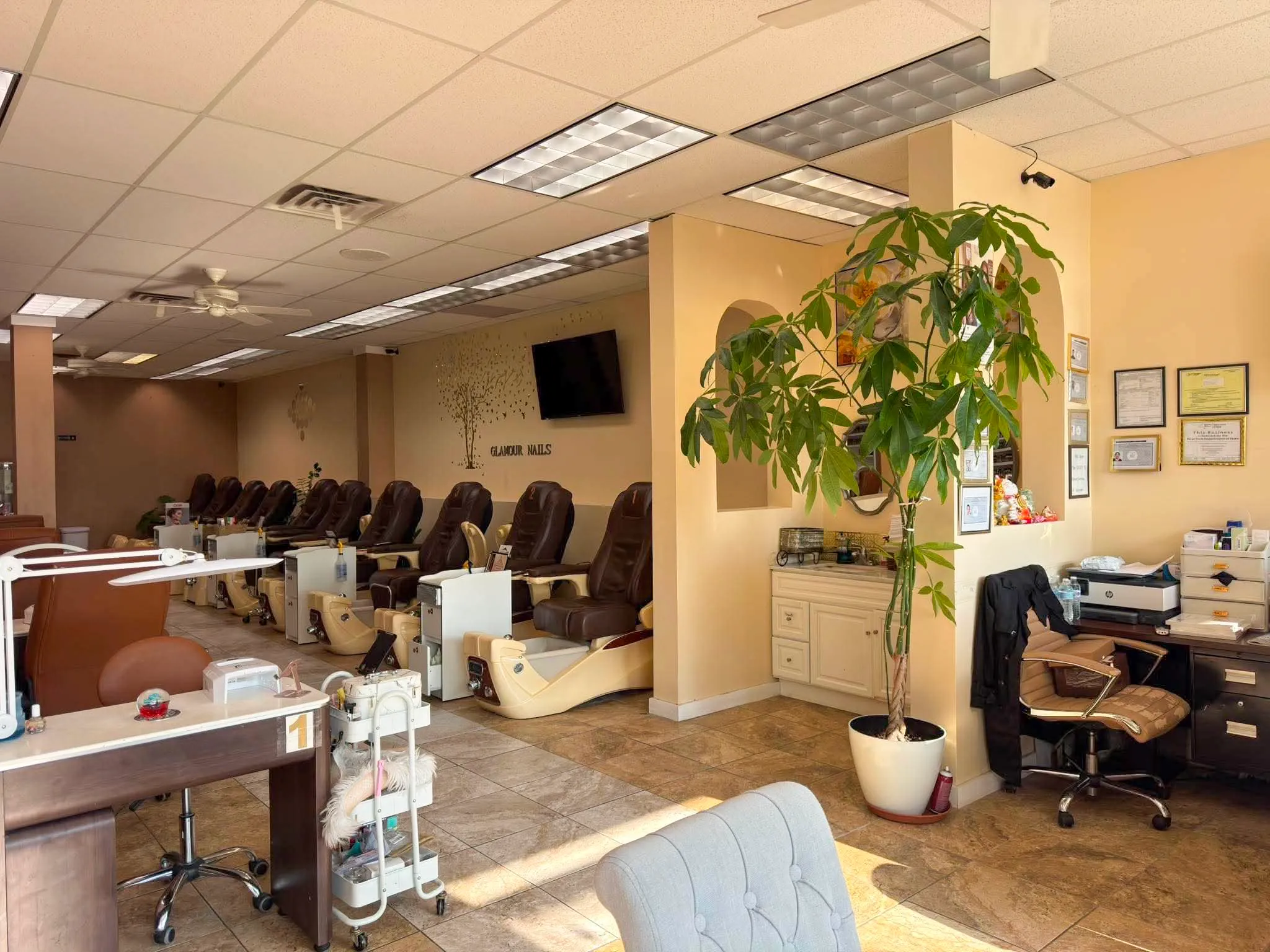 Glamour Nails salon interior in Blasdell, NY — spa pedicure chairs, manicure stations and the Glamour Nails wall sign