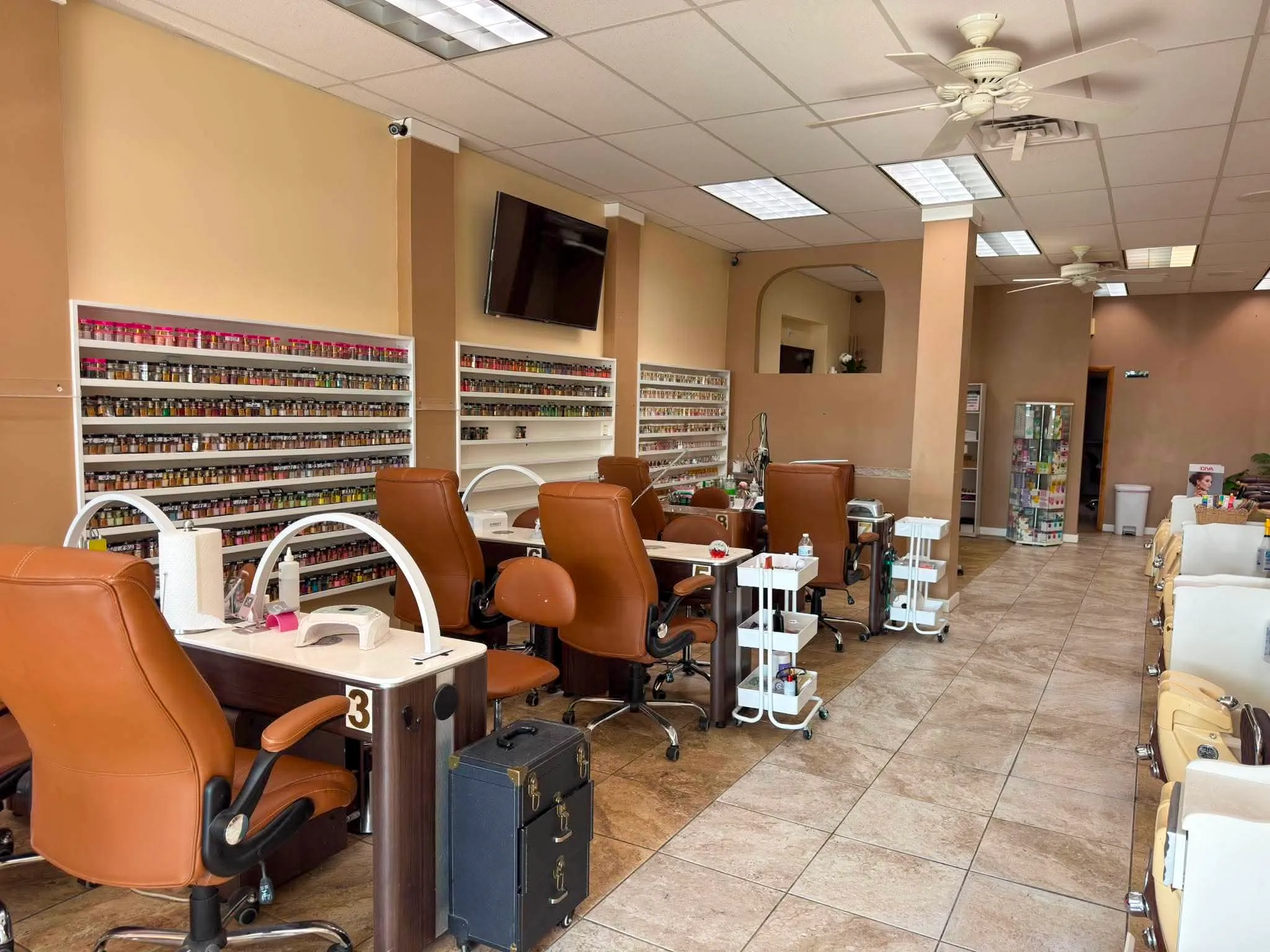 Glamour Nails salon interior in Blasdell, NY — manicure stations and the nail polish color wall